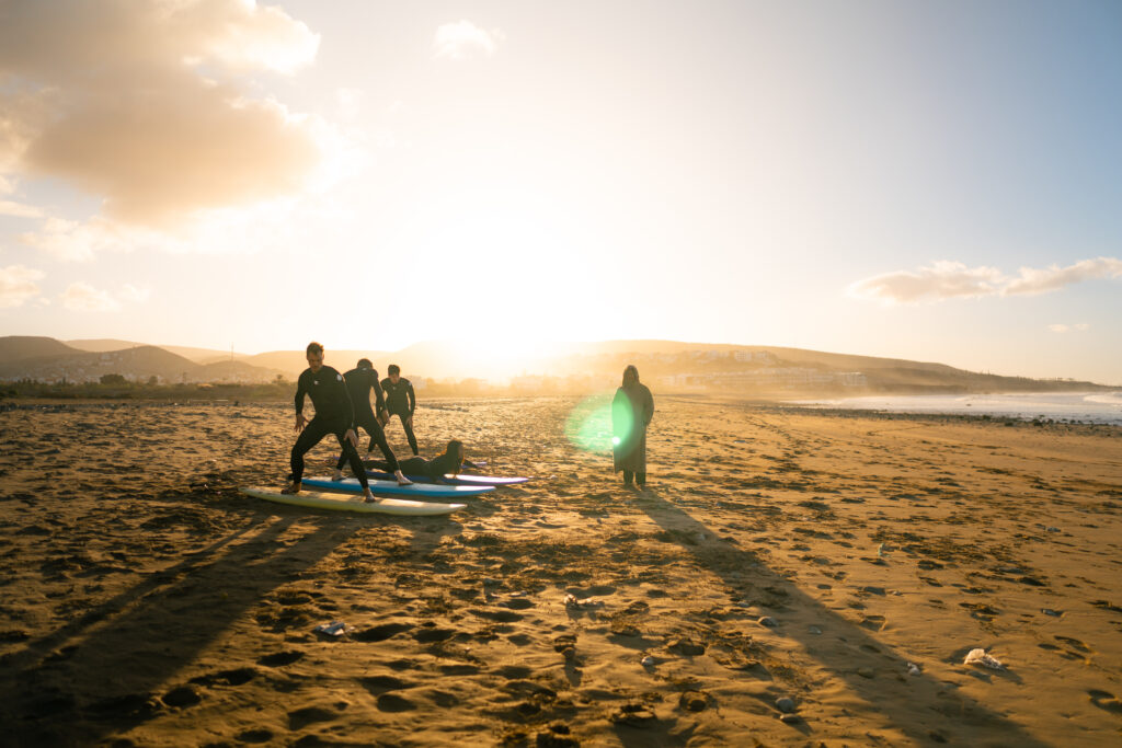 Beginner surf package Morocco first time surfer standing riding wave Devil's Rock Tamraght ISA instructor coaching