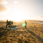 Beginner surf package Morocco first time surfer standing riding wave Devil's Rock Tamraght ISA instructor coaching