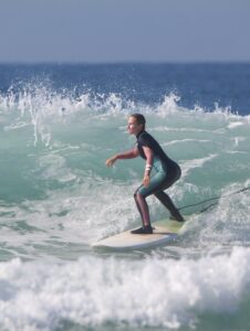 Surfer in a wetsuit riding a wave in Taghazout Bay