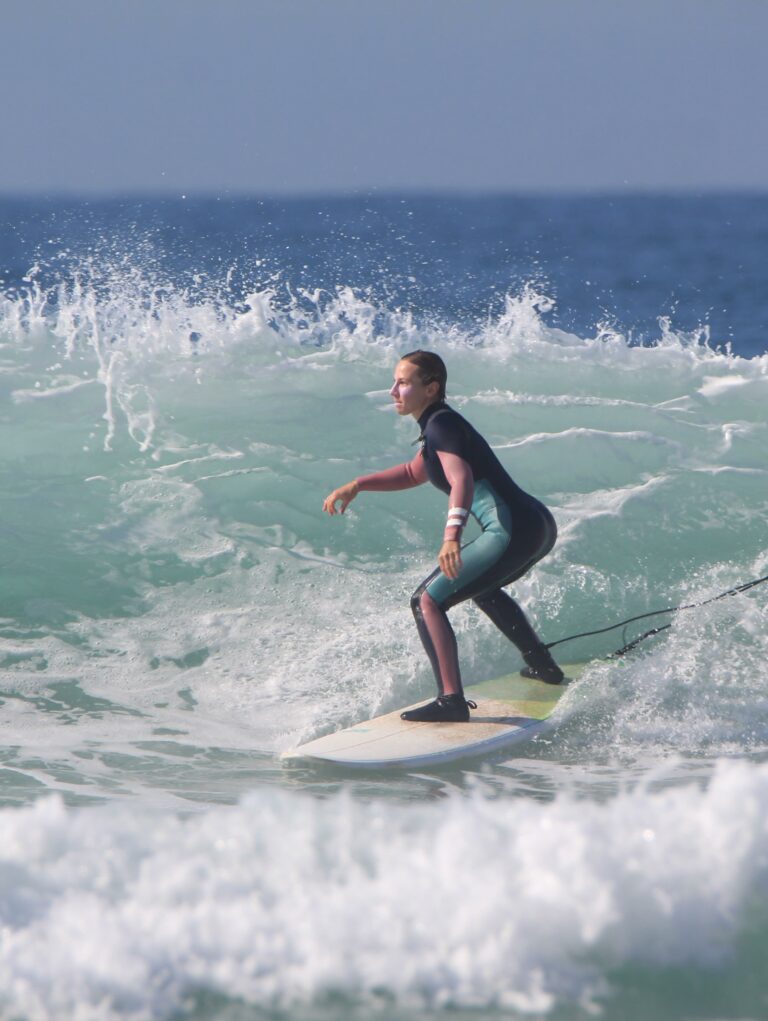 Surfer in a wetsuit riding a wave in Taghazout Bay