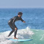 Surfer riding a wave on a sunny day in Taghazout Bay