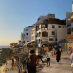 Colourful hillside houses by the ocean in Taghazout Bay at golden hour