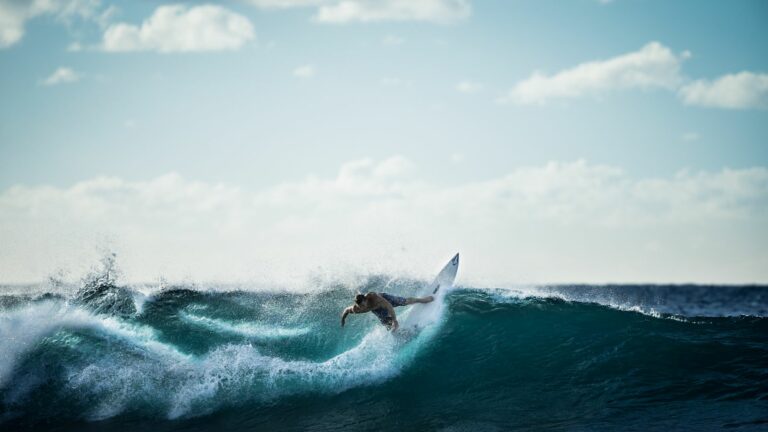 Surfer carving a turn on a white shortboard
