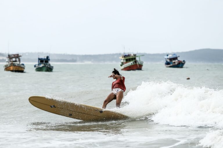 Woman surfing a small wave on a longboard